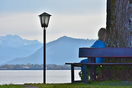 woman in blue top sitting on bench