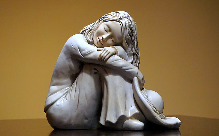 white ceramic statue of sleeping woman