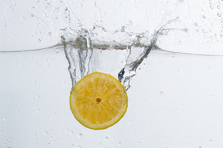 underwater photo of sliced lemon drop in water