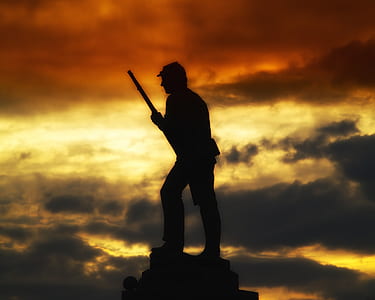 silhouette of man holding rifle