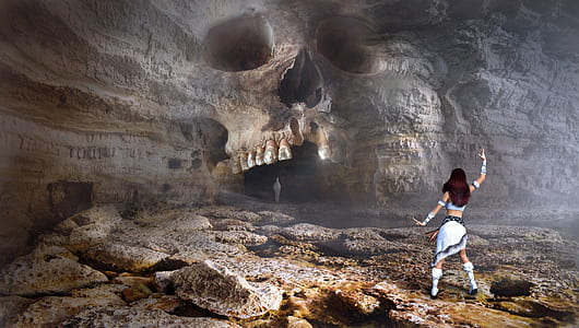 woman wearing white dress in front of skull cave illustration
