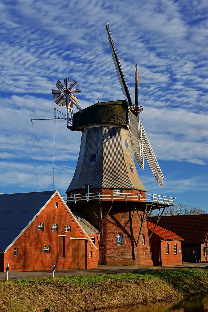 gray windmill beside brown house