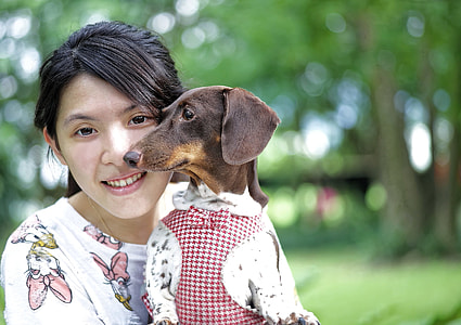 photo of woman wearing white top beside brown dog