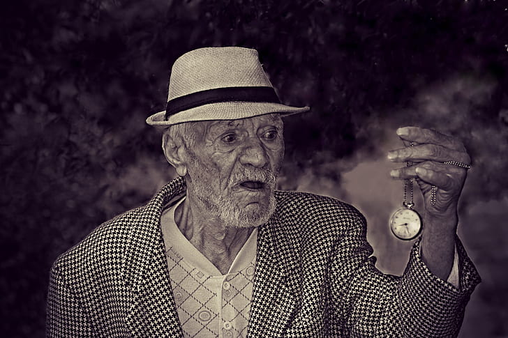 grayscale photo of man holding pocket watch