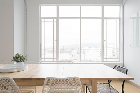 rectangular beige dining table across white window frame