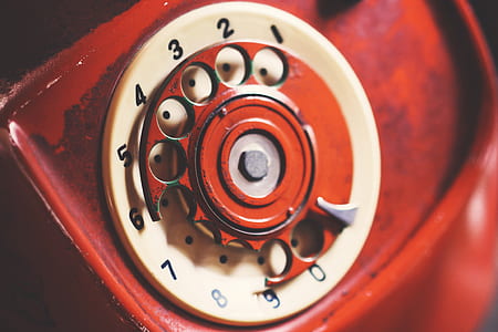 red and white rotary phone selective focus photography