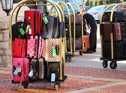 person taking photo of assorted luggage bag lot