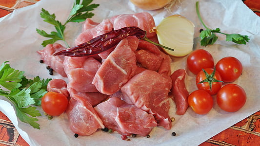 raw meat beside tomatoes and onion