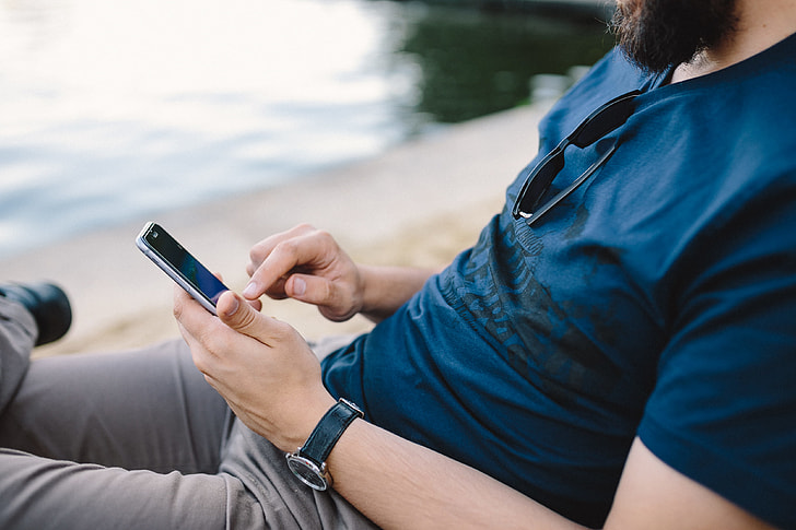 Young Man Using His Phone on beach