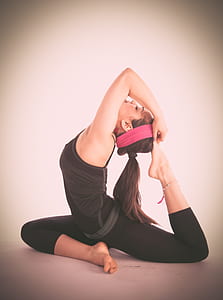 woman in black sleeveless shirt doing yoga