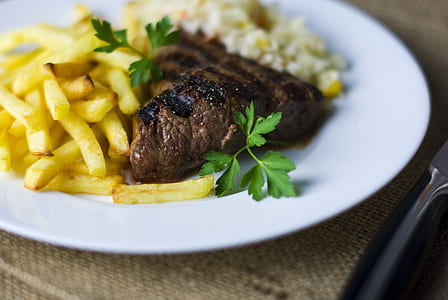 selective focus photography of grilled meat with potato fries