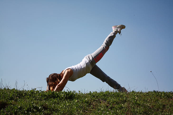 woman bending on green field