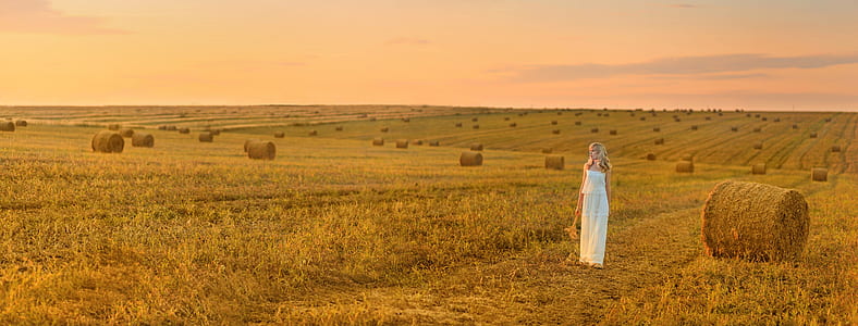 woman in white gown on hay lawn