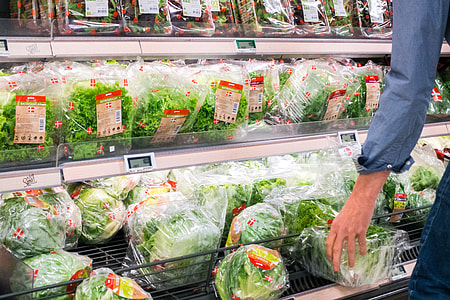 Woman picking lettuce in a grocery store