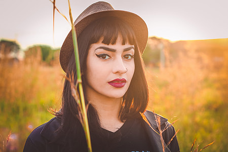 Portrait shot of a woman model wearing a hat in a field
