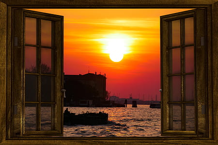 beige wooden frame 8-lite window near ocean over silhouette of building at sunset