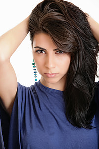 woman wearing blue top and teal dangling earrings
