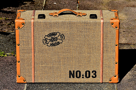 brown suitcase on gray concrete flooring