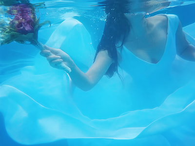 woman in white wedding dress underwater photography