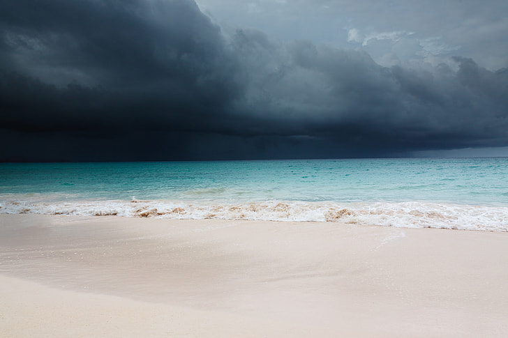 photo of black storm near seashore during daytime