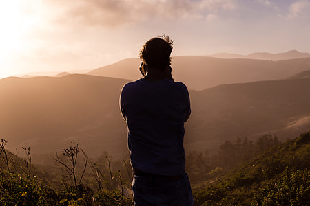 photography of a man in the top of mountain during sunset