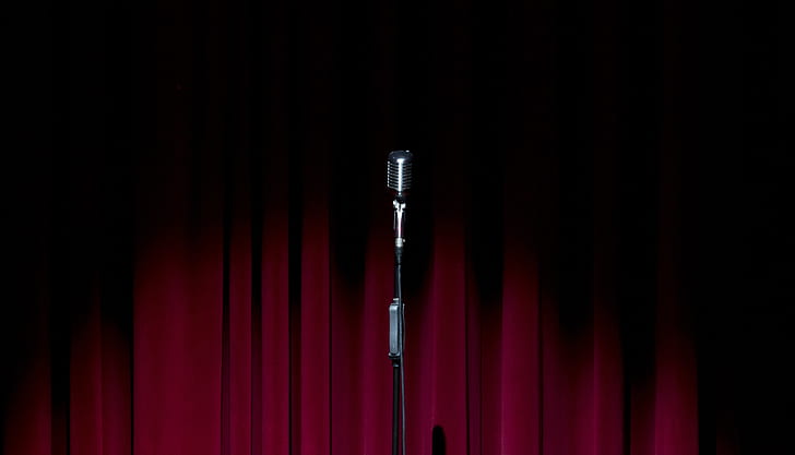 black microphone near red curtian