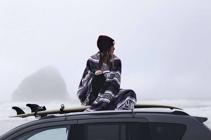 woman sitting on top of vehicle
