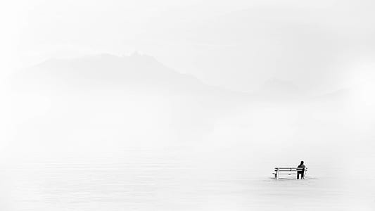 landscape photography of person sitting on white bench