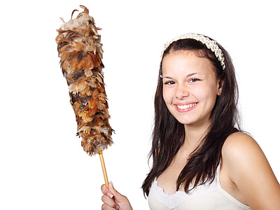 woman in white and beige spaghetti strap shirt holding feather duster