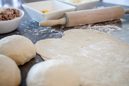 photo of rolling pin beside dough on table