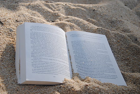 opened book on brown sand
