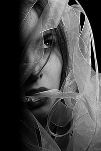 grayscale photo of woman biting veil