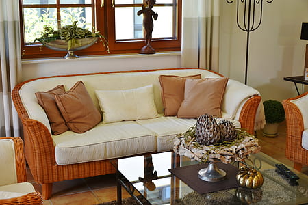 brown wicker couch with white cushions and throw pillows