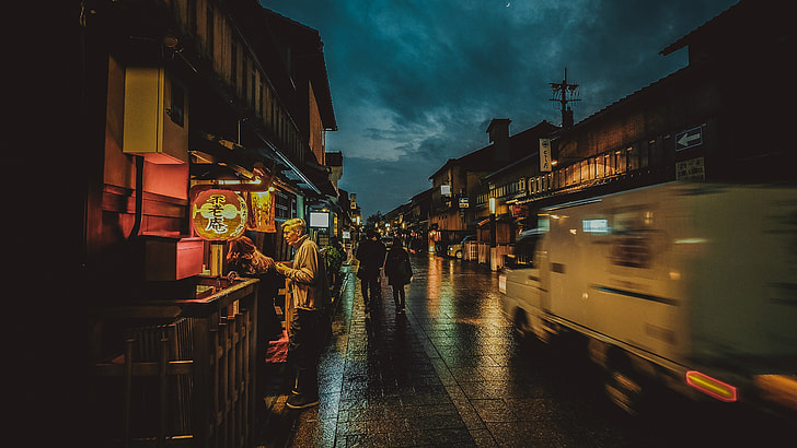 man standing near food stall at night time