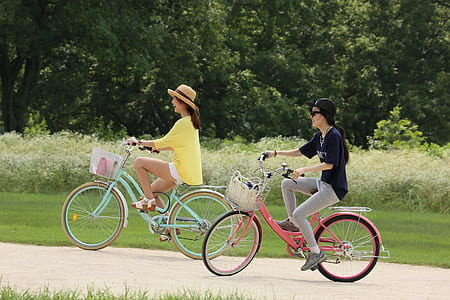 two women riding bicycles during daytime