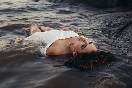 woman with closed eyes floating on water