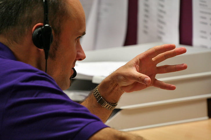 man in purple top doing hand gesture