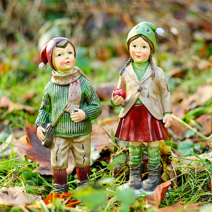 girl and a boy in green and red bobble hat figurines