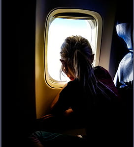 girl watching on skies near airplane window