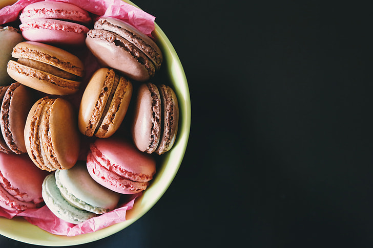 Macarons in a bowl on a dark background