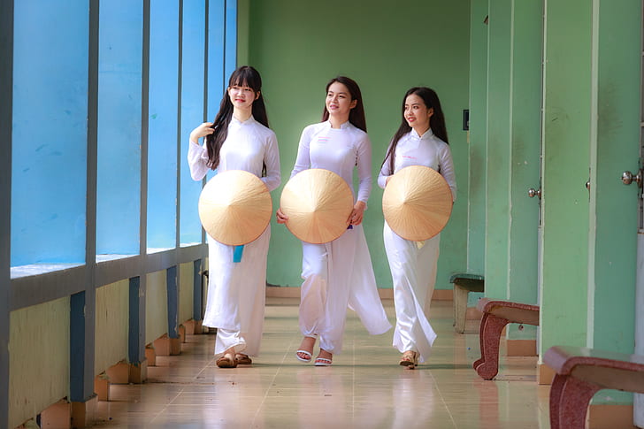 photo of three women wearing white long-sleeved dresses