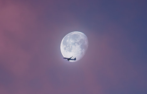 airplane under moon on sky