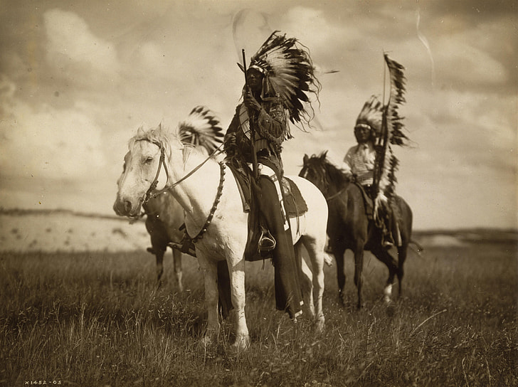 grayscale photo of three Native Americans riding horses