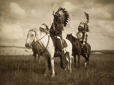grayscale photo of three Native Americans riding horses