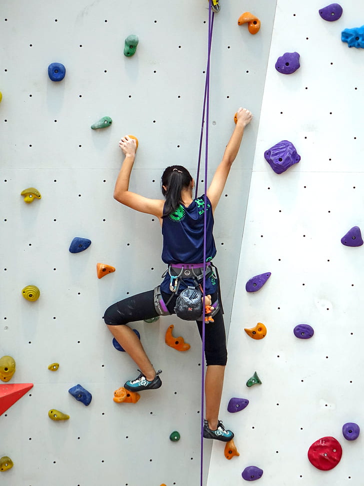 woman doing indoor wall climbing