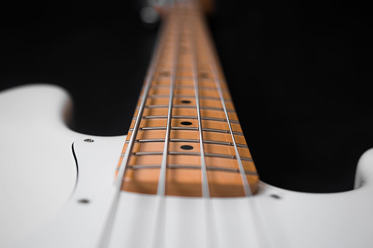 close-up photography of white 4-string bass guitar