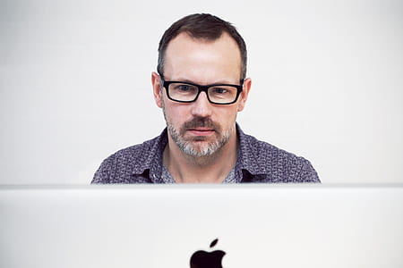 man in black button-top in front of iMac