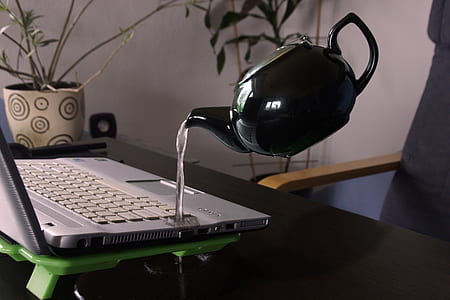 White Kettle Droping Water on Silver Laptop Computer