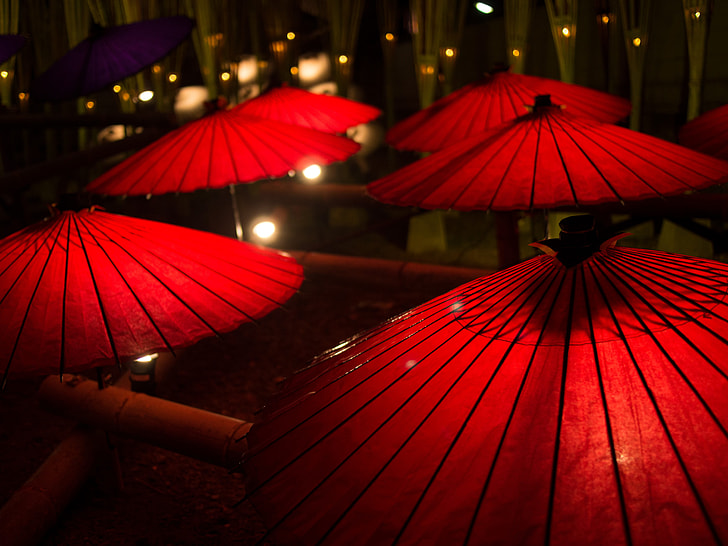 six red japanese umbrellas at nighttime
