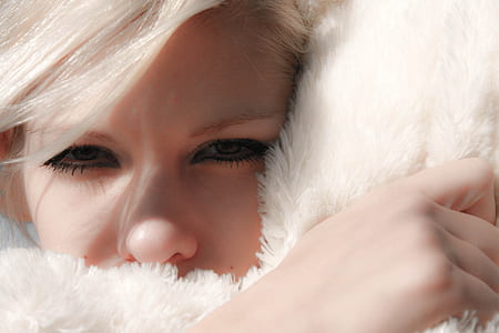 woman head on white fur pillow